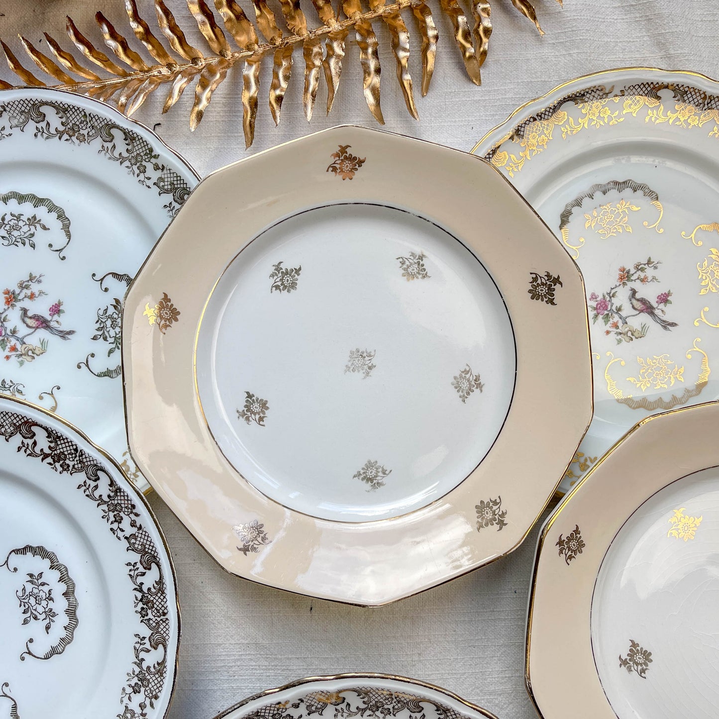 Lot de 8 petites assiettes dépareillées en porcelaine française des années 1950, 4 Limoges à motif oiseaux dorés et 4 Moulin des Loups à bordure crème, décor floral doré, style vintage