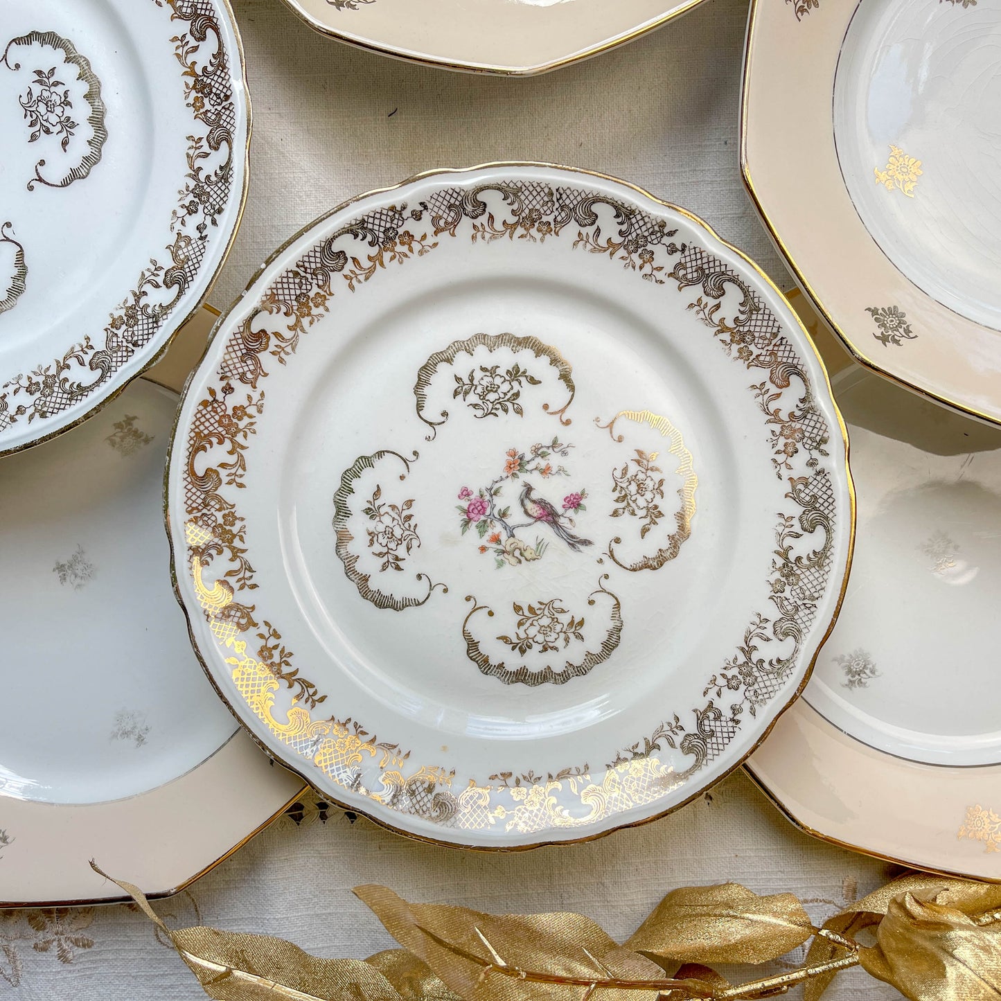 Lot de 8 petites assiettes dépareillées en porcelaine française des années 1950, 4 Limoges à motif oiseaux dorés et 4 Moulin des Loups à bordure crème, décor floral doré, style vintage