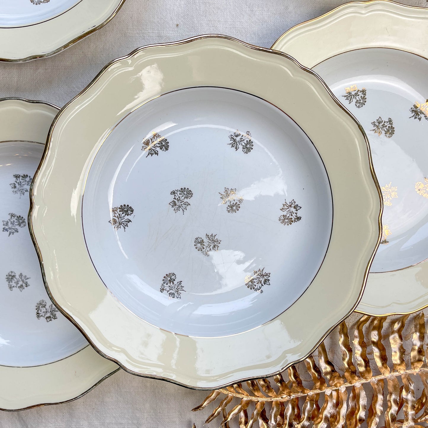 Assiettes vintage en porcelaine blanche ornées d’un motif floral doré et d’une bordure jaune pastel – Fabrication L'Amandinoise, années 1950