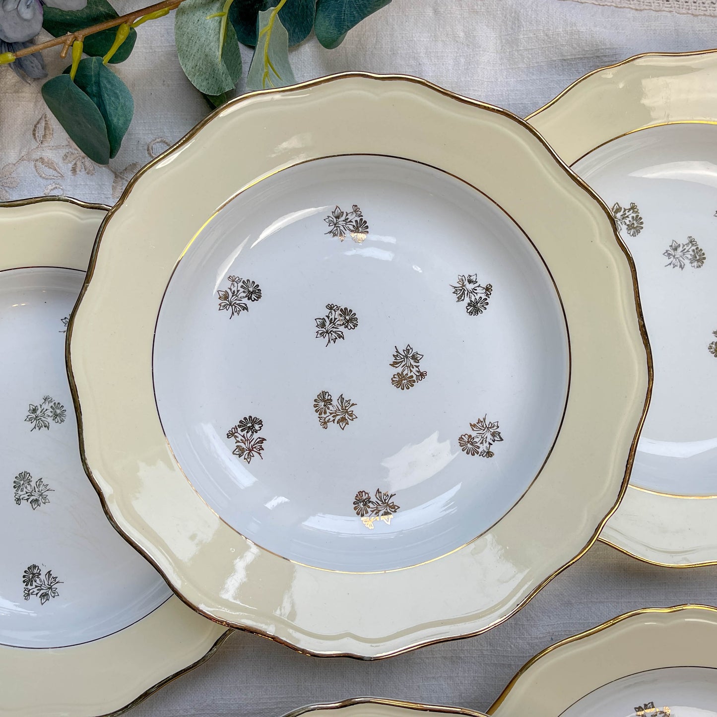 Assiettes vintage en porcelaine blanche ornées d’un motif floral doré et d’une bordure jaune pastel – Fabrication L'Amandinoise, années 1950