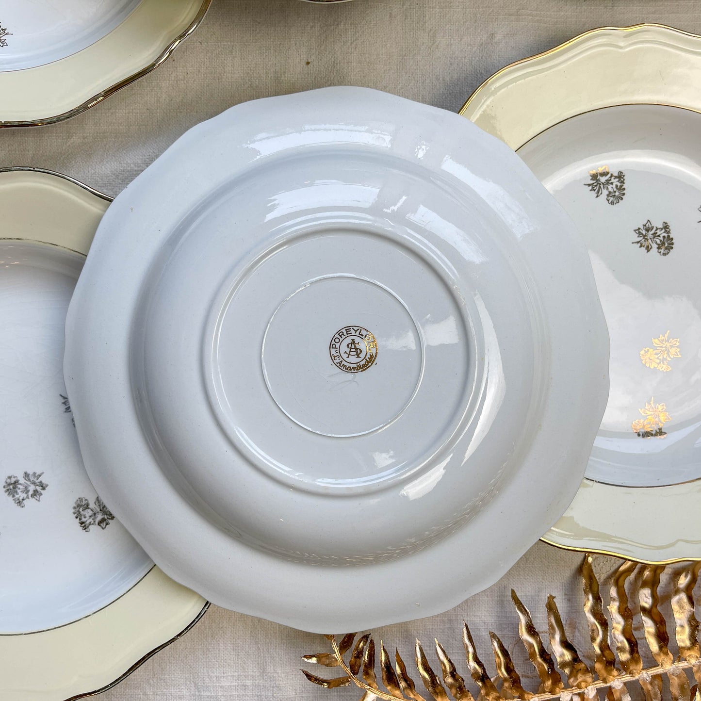 Assiettes vintage en porcelaine blanche ornées d’un motif floral doré et d’une bordure jaune pastel – Fabrication L'Amandinoise, années 1950