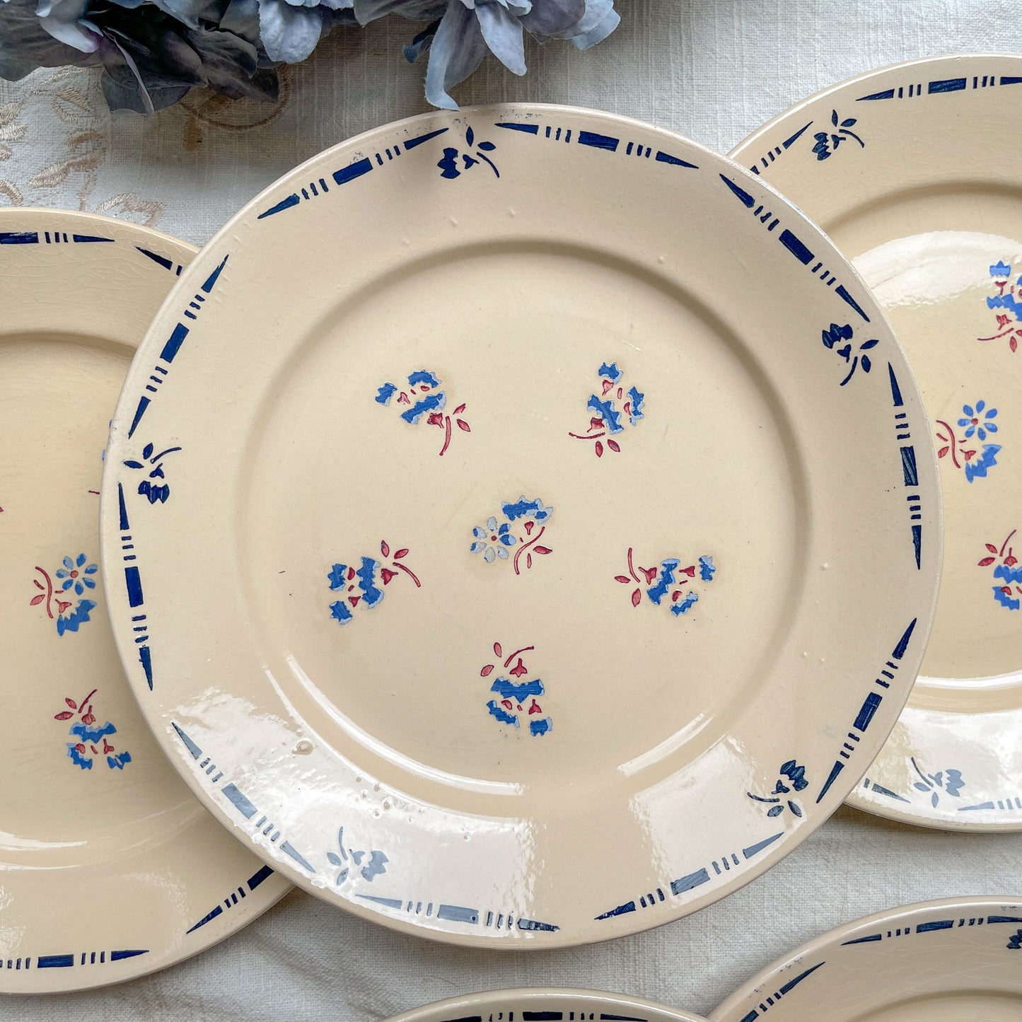 Lot de 6 assiettes plates en porcelaine vintage K&G Lunéville, modèle "Flore" des années 1950, décorées de petites fleurs bleues délicates.