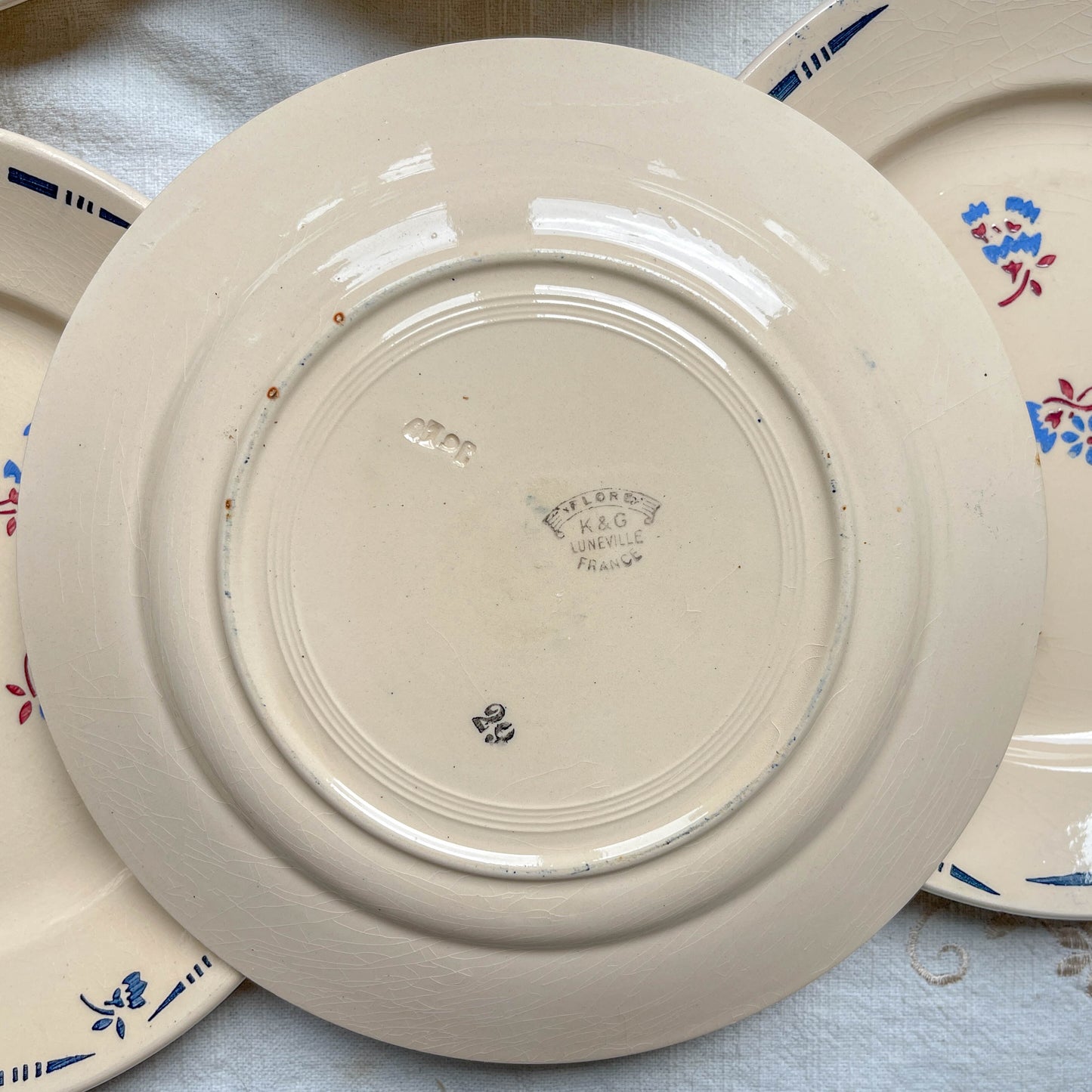 Lot de 8 assiettes plates en porcelaine vintage K&G Lunéville, modèle "Flore" des années 1950, décorées de petites fleurs bleues délicates.