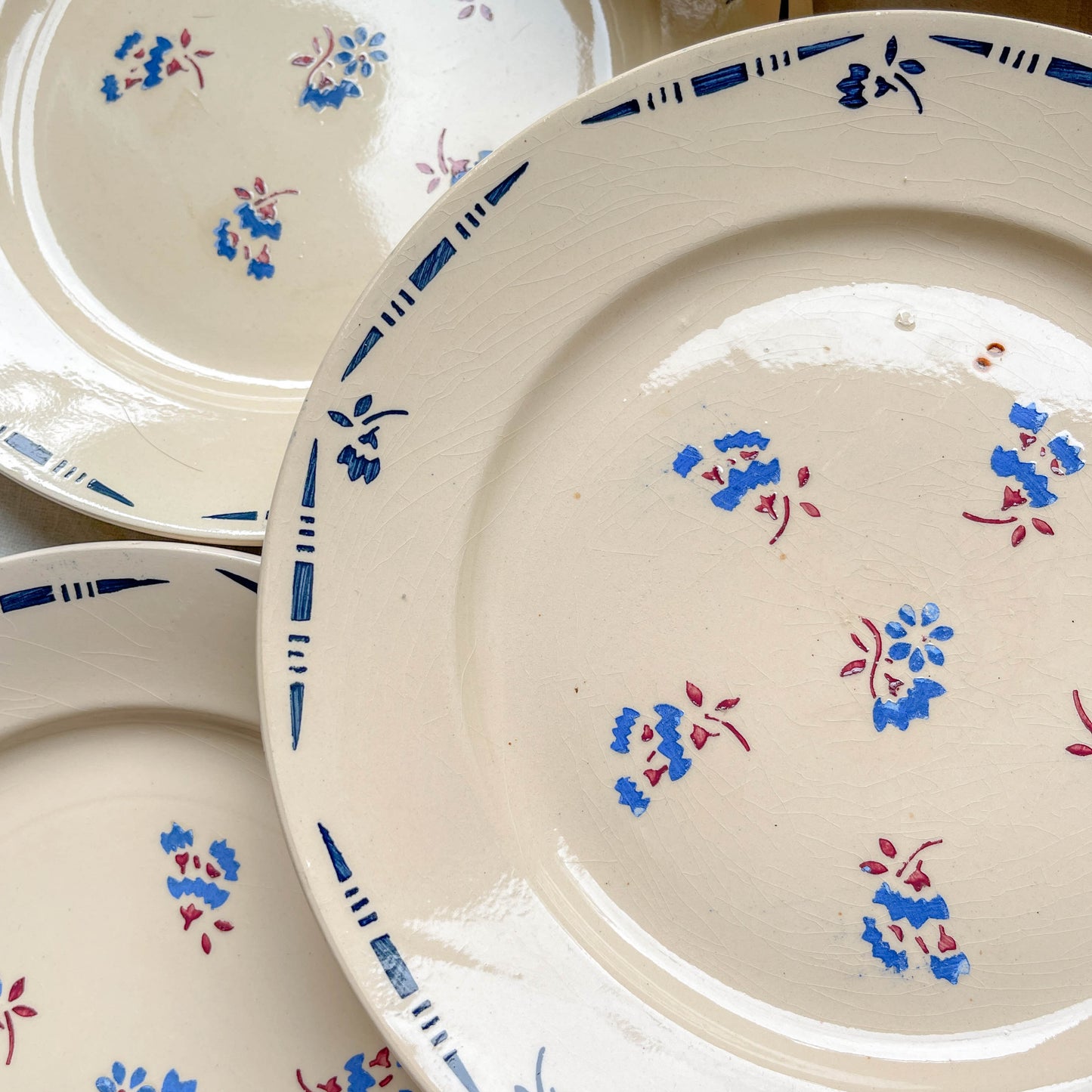 Lot de 8 assiettes plates en porcelaine vintage K&G Lunéville, modèle "Flore" des années 1950, décorées de petites fleurs bleues délicates.