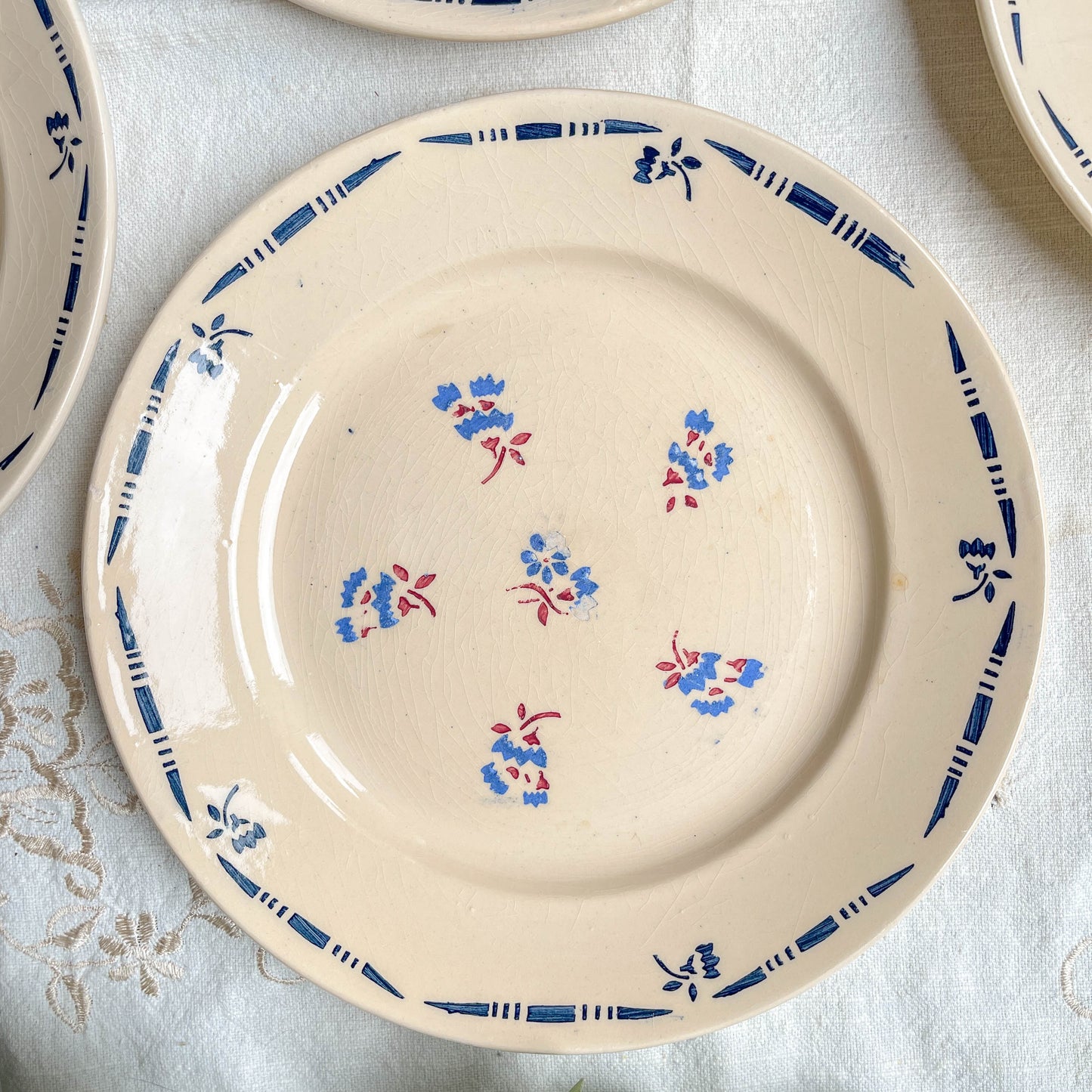 Lot de 8 assiettes plates en porcelaine vintage K&G Lunéville, modèle "Flore" des années 1950, décorées de petites fleurs bleues délicates.