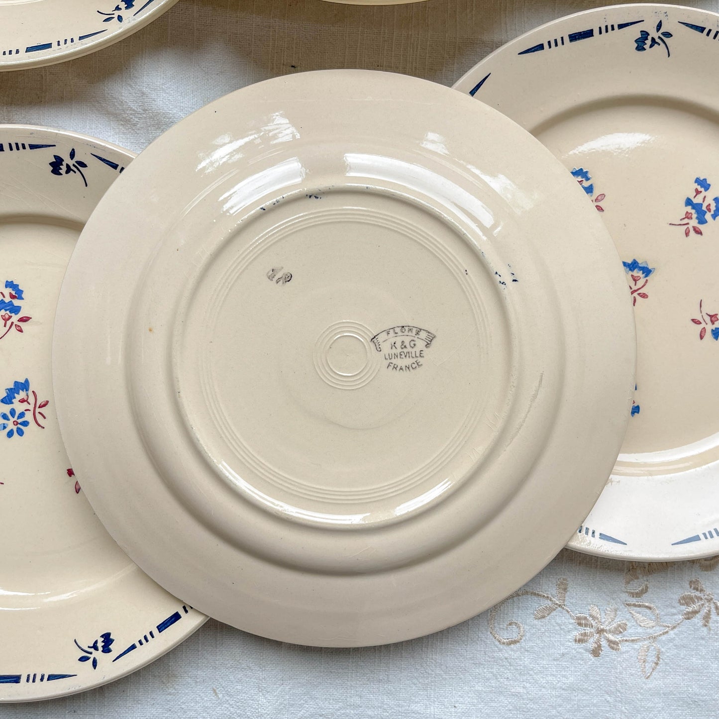 Lot de 6 assiettes plates en porcelaine vintage K&G Lunéville, modèle "Flore" des années 1950, décorées de petites fleurs bleues délicates.