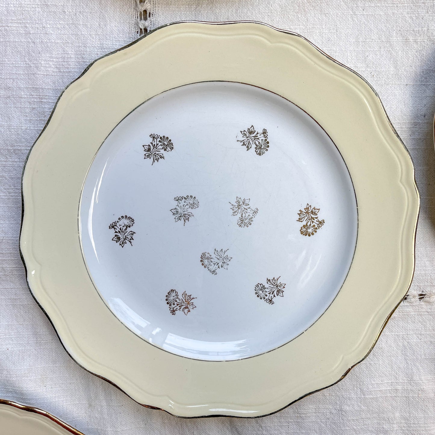 Assiettes vintage en porcelaine blanche ornées d’un motif floral doré et d’une bordure jaune pastel – Fabrication L'Amandinoise, années 1950