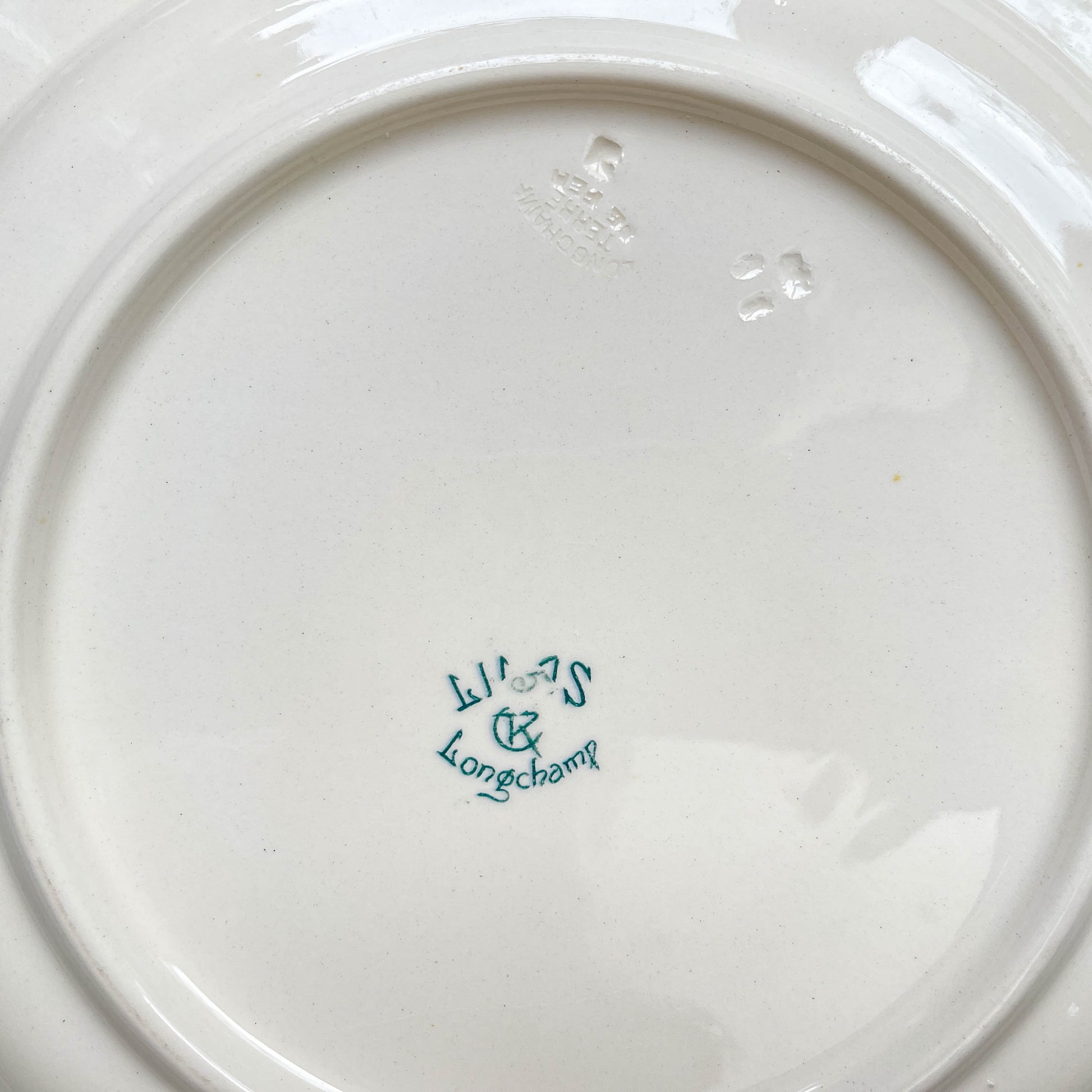 Plat rond ancien en Terre de Fer modèle "Lilas" de la manufacture Longchamp, fin XIXe siècle – Vaisselle vintage française avec décor floral bleu.