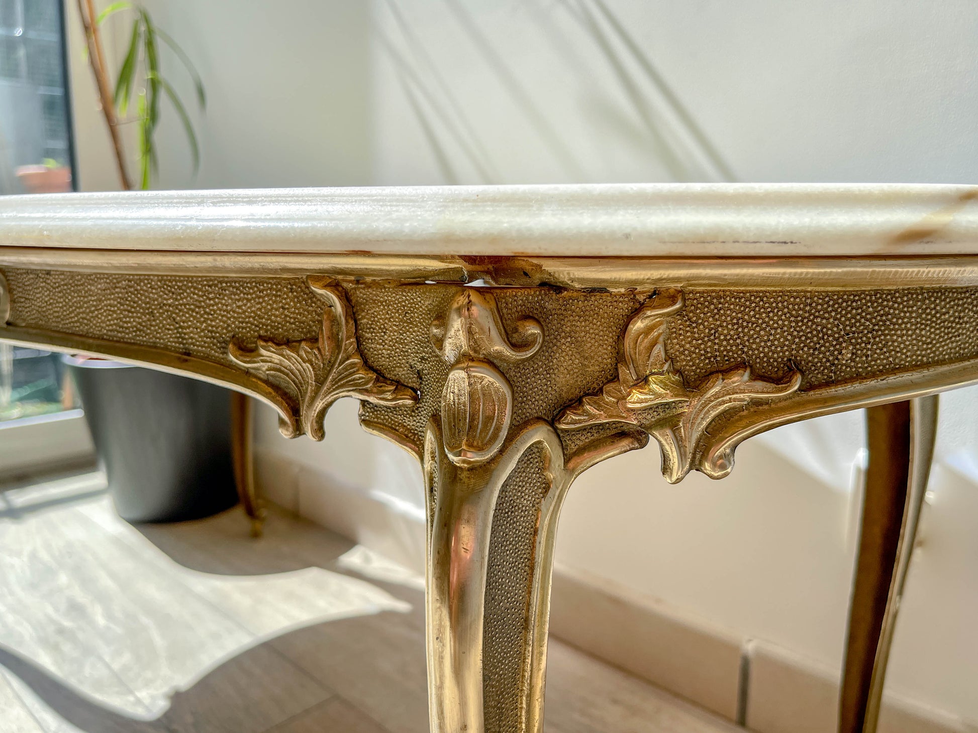 Table basse vintage ovale avec plateau en marbre blanc et pieds en bronze patiné, style chic et rétro pour salon.