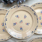 Lot de 6 assiettes plates en porcelaine vintage K&G Lunéville, modèle "Flore" des années 1950, décorées de petites fleurs bleues délicates.
