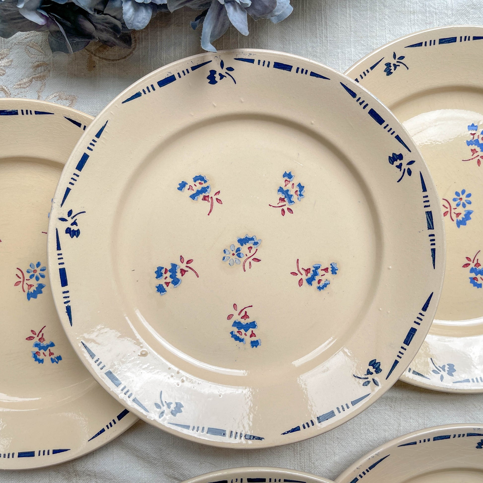 Lot de 6 assiettes plates en porcelaine vintage K&G Lunéville, modèle "Flore" des années 1950, décorées de petites fleurs bleues délicates.