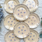 Lot de 8 assiettes plates en porcelaine vintage K&G Lunéville, modèle "Flore" des années 1950, décorées de petites fleurs bleues délicates.