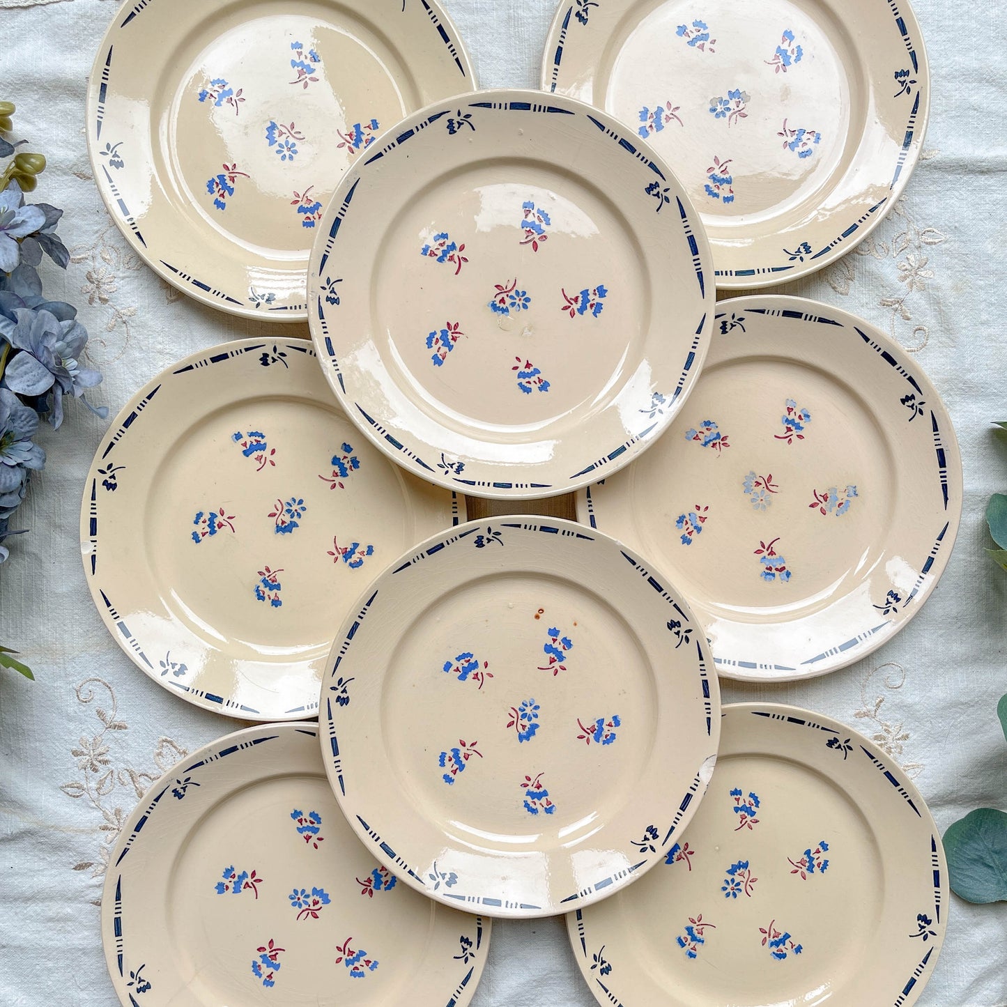 Lot de 8 assiettes plates en porcelaine vintage K&G Lunéville, modèle "Flore" des années 1950, décorées de petites fleurs bleues délicates.