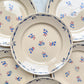 Lot de 8 assiettes plates en porcelaine vintage K&G Lunéville, modèle "Flore" des années 1950, décorées de petites fleurs bleues délicates.