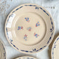 Lot de 8 assiettes plates en porcelaine vintage K&G Lunéville, modèle "Flore" des années 1950, décorées de petites fleurs bleues délicates.