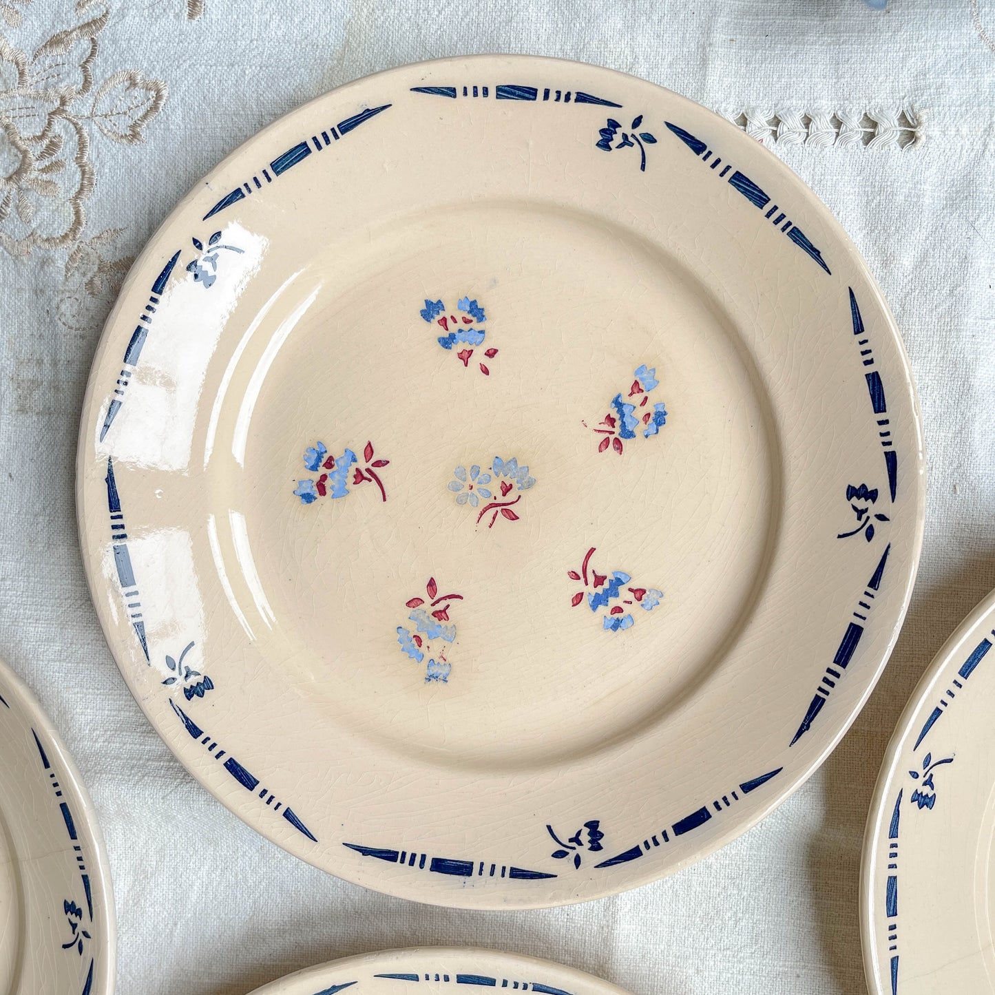 Lot de 8 assiettes plates en porcelaine vintage K&G Lunéville, modèle "Flore" des années 1950, décorées de petites fleurs bleues délicates.