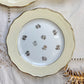 Assiettes vintage en porcelaine blanche ornées d’un motif floral doré et d’une bordure jaune pastel – Fabrication L'Amandinoise, années 1950

