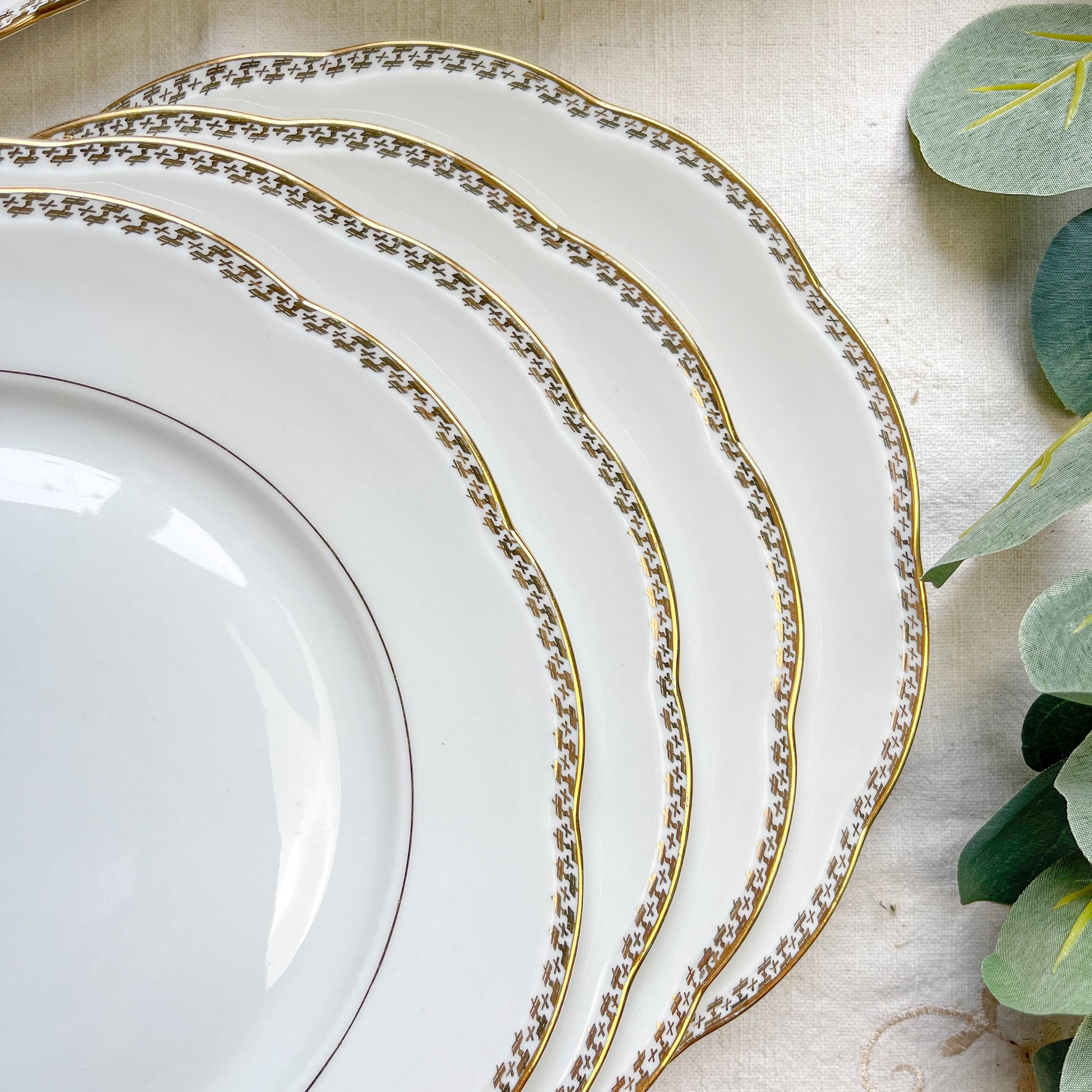 Ensemble de 7 assiettes plates vintage en porcelaine blanche avec décor doré géométrique SPF, vaisselle ancienne élégante pour table rétro ou collection.