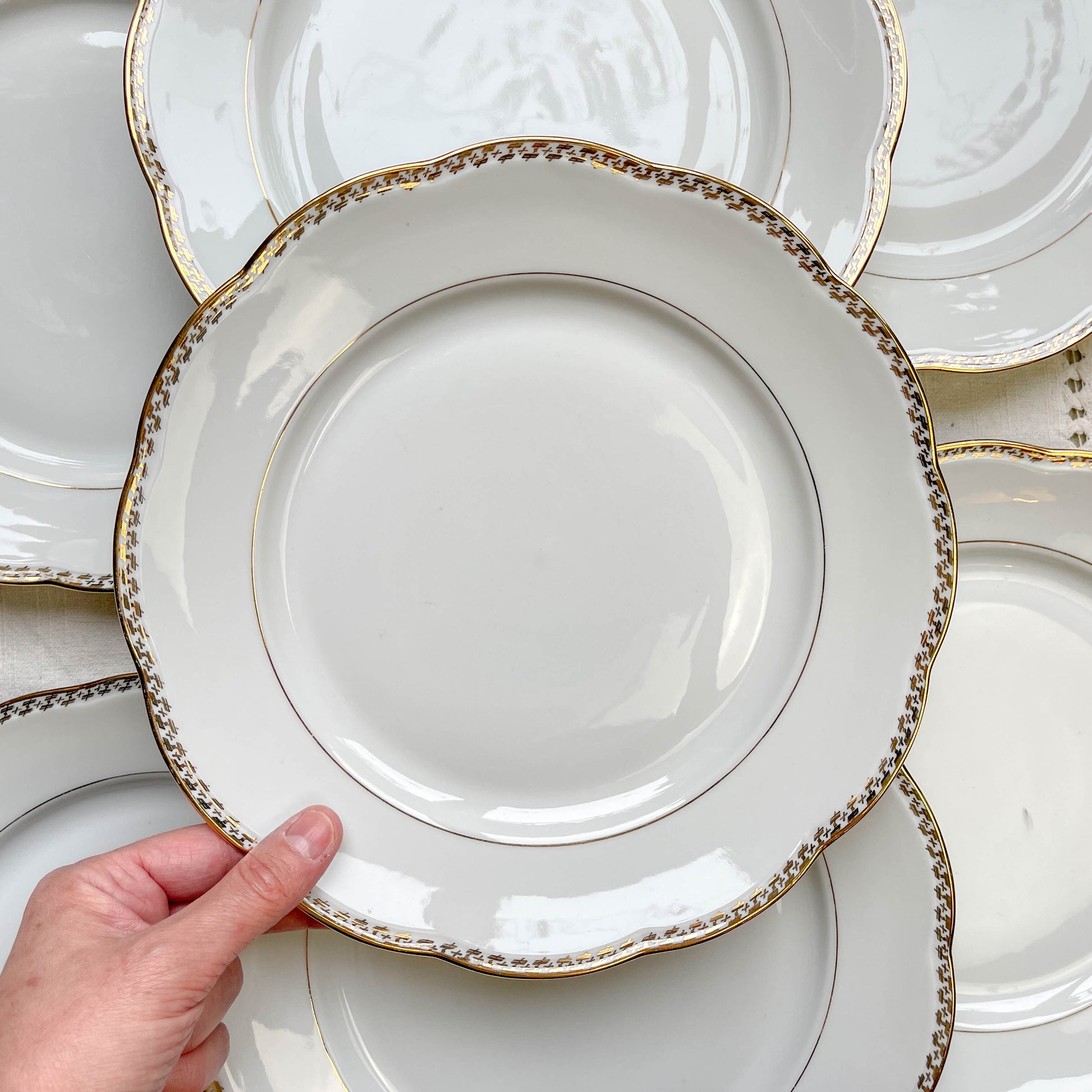 Ensemble de 7 assiettes plates vintage en porcelaine blanche avec décor doré géométrique SPF, vaisselle ancienne élégante pour table rétro ou collection.