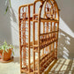 Étagère pliante en rotin vintage des années 1950, structure légère et naturelle, parfaite comme bibliothèque murale ou rangement décoratif pour une chambre d’enfant ou un intérieur bohème.