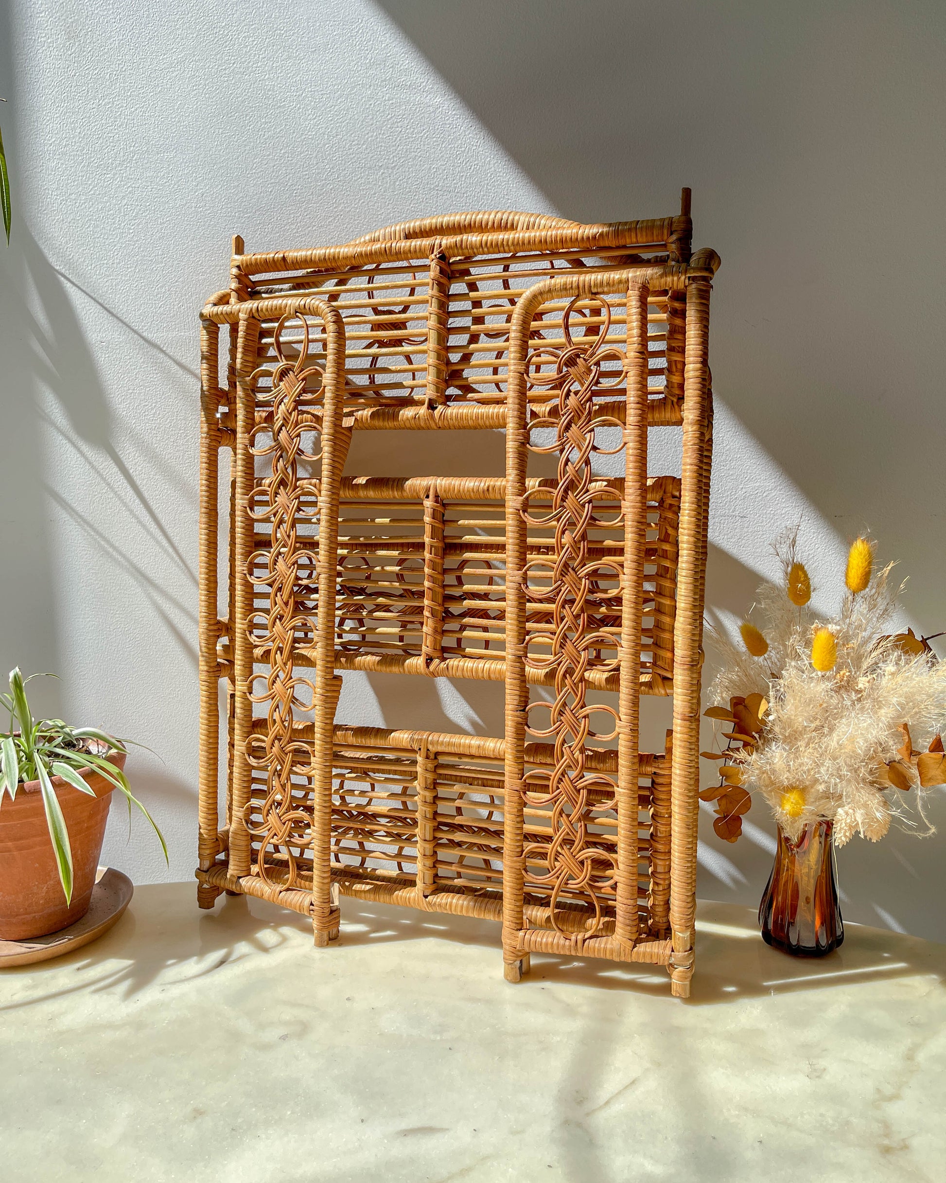 Étagère pliante en rotin vintage des années 1950, structure légère et naturelle, parfaite comme bibliothèque murale ou rangement décoratif pour une chambre d’enfant ou un intérieur bohème.
