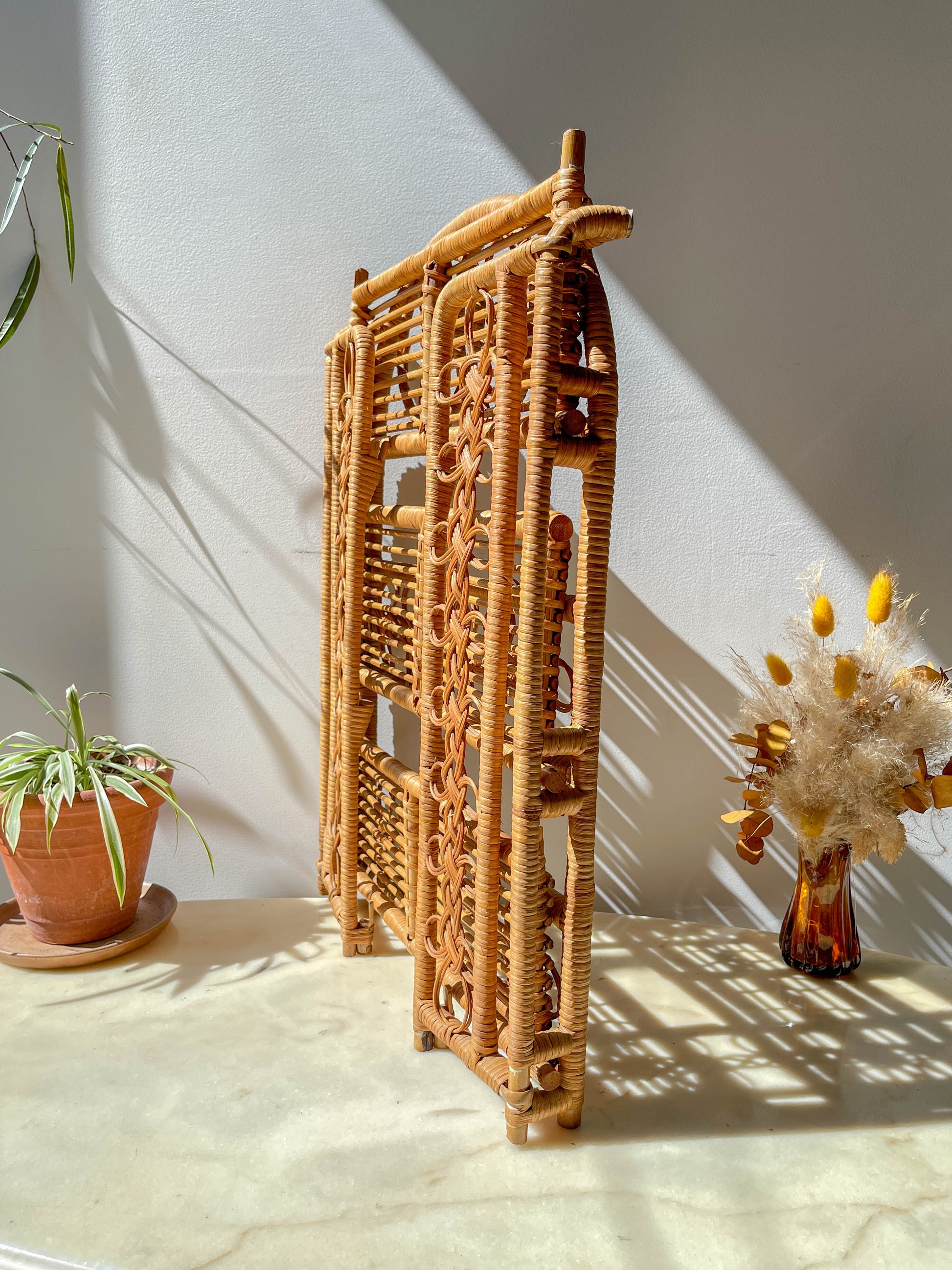 Étagère pliante en rotin vintage des années 1950, structure légère et naturelle, parfaite comme bibliothèque murale ou rangement décoratif pour une chambre d’enfant ou un intérieur bohème.