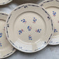 Lot de 6 assiettes plates en porcelaine vintage K&G Lunéville, modèle "Flore" des années 1950, décorées de petites fleurs bleues délicates.